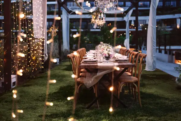 Pergola im A-ROSA Gardasee Ein Tisch für eine Dinnerparty gedeckt, mit Kerzen und Beleuchtung. Perfekt für eine Hochzeitsfeier im Garten.