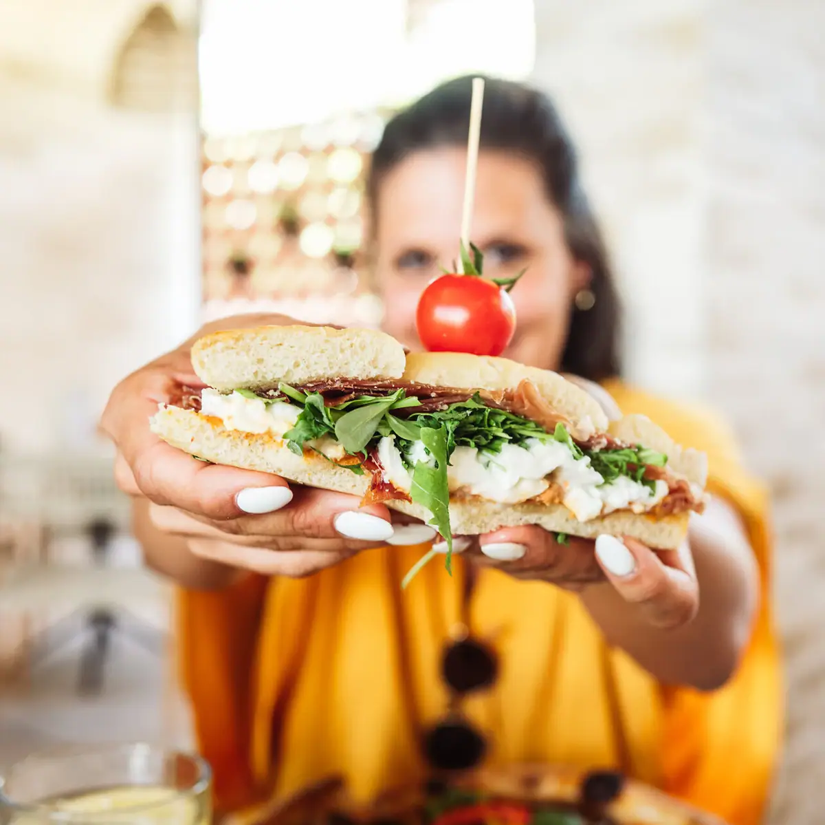 Eine Frau hält ein Sandwich.