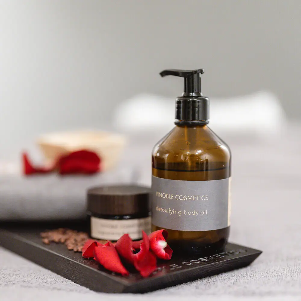Vinoble Cosmetics Angeordnete Pflegeprodukte mit Rosenblättern
