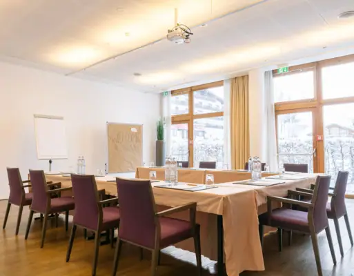 Tagungsraum A-ROSA Kleinwalsertal Ein heller Tagungsraum mit einem Tisch und Stühlen.