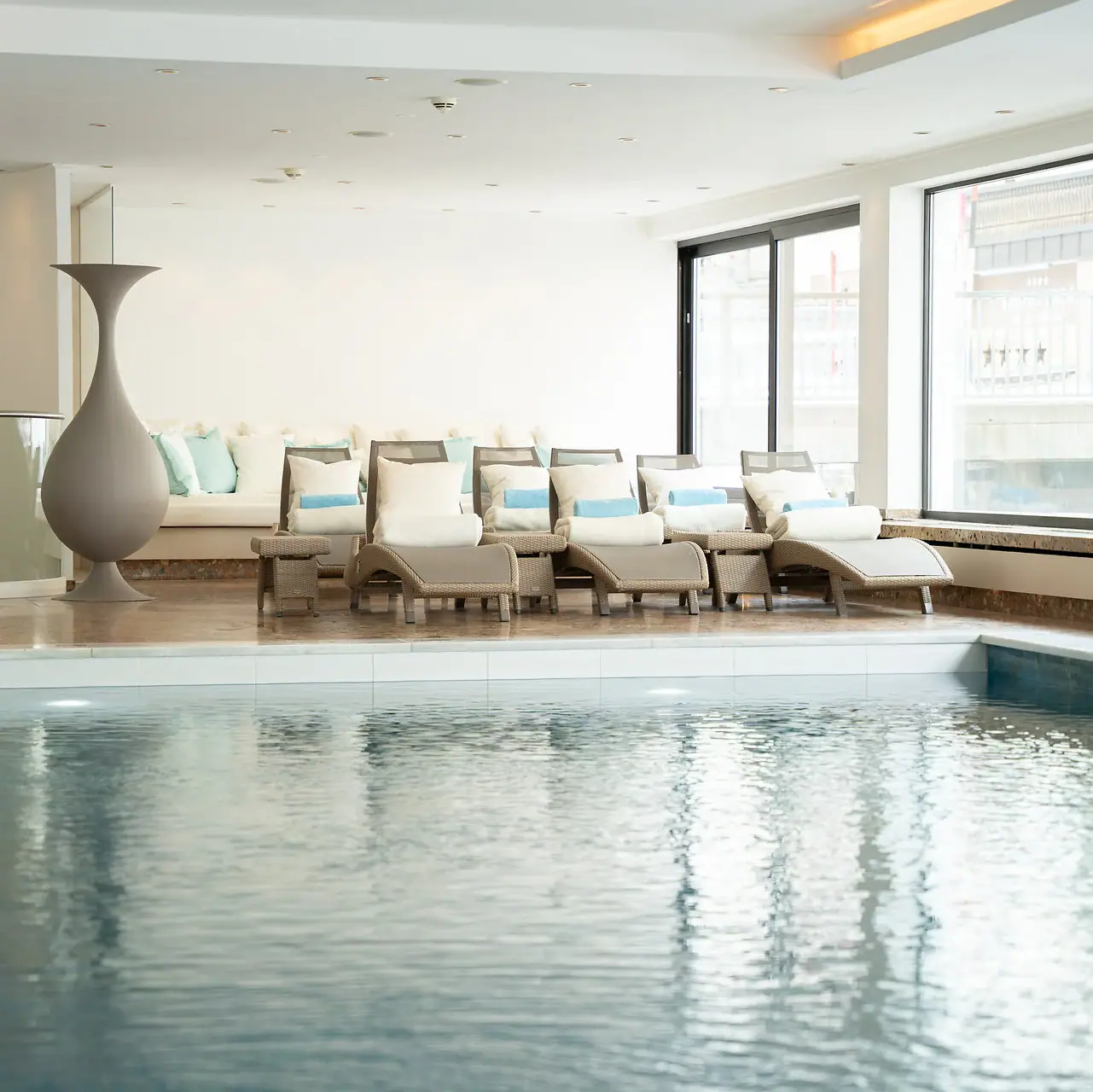 Innenpool mit großer Vase und Stühlen.