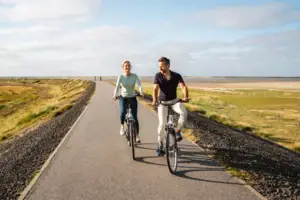 Fahrradfahren Ein Mann und eine Frau fahren auf einer Straße Fahrrad.