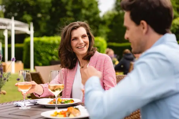 Paar Ein Mann und eine Frau sitzen an einem Tisch mit Essen und Getränken.