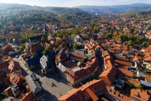 Wernigerode Luftaufnahme einer Stadt mit Häusern, Bäumen und Bergen im Hintergrund.