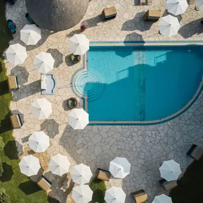 Ein Außenpool mit Sonnenschirmen und Liegestühlen.