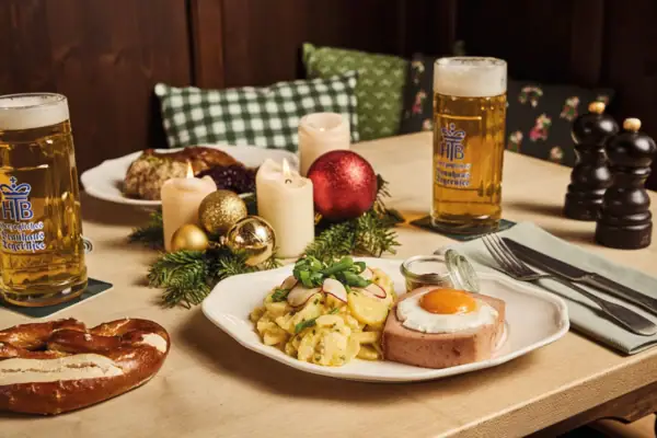 Ein Teller mit Essen und ein Bier auf einem Tisch.