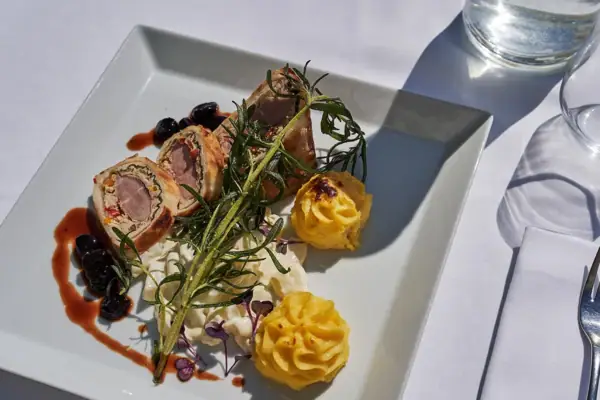 Ein Teller mit kunstvoll angerichtetem Essen auf einem Tisch.