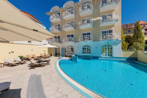 Außenpool Ein Swimmingpool neben einem Gebäude im Freien.