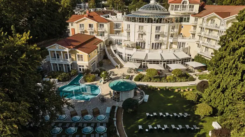 Ein Gebäude mit einem Pool und Liegestühlen im Freien.