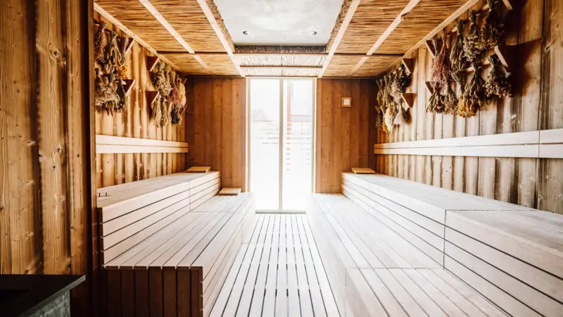 SPA-Welten Ein Raum mit Holzbänken und einer Tür.