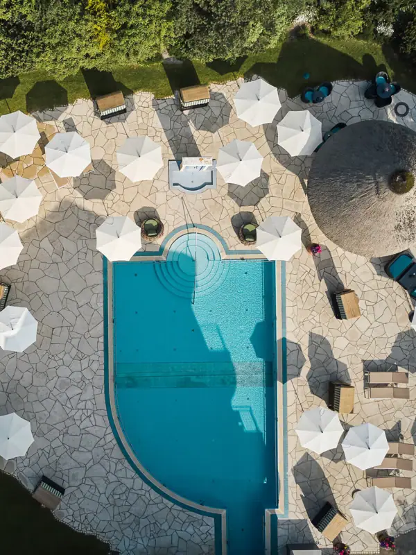 Luftaufnahme eines Pools mit Sonnenschirmen