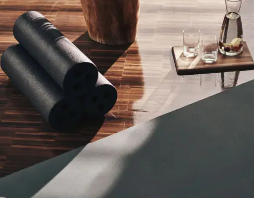 Yogamatten und Gläser auf einem Holzboden