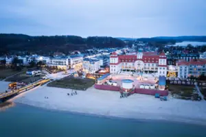 Kurhaus Binz Stadtansicht mit Gebäuden und Strand im Vordergrund.