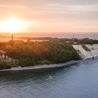 Ein Gewässer mit einem Leuchtturm auf einem Hügel.