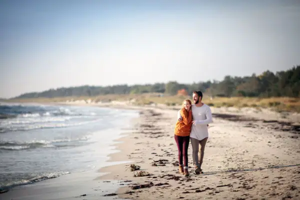 Strand Travemünde Ein Mann und eine Frau spazieren am Strand.
