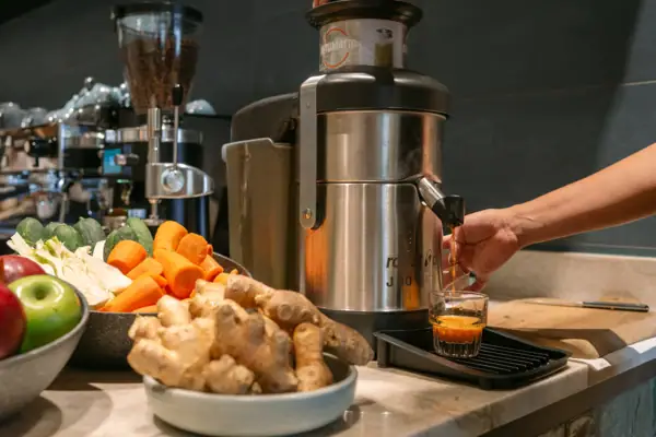 Eine Hand gießt ein Getränk in ein Glas.