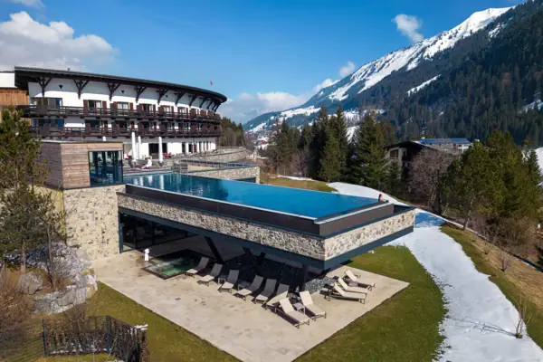 A-ROSA Ifen Hotel Kleinwalsertal Ein Schwimmbecken in einem Gebäude mit einem Berg im Hintergrund.