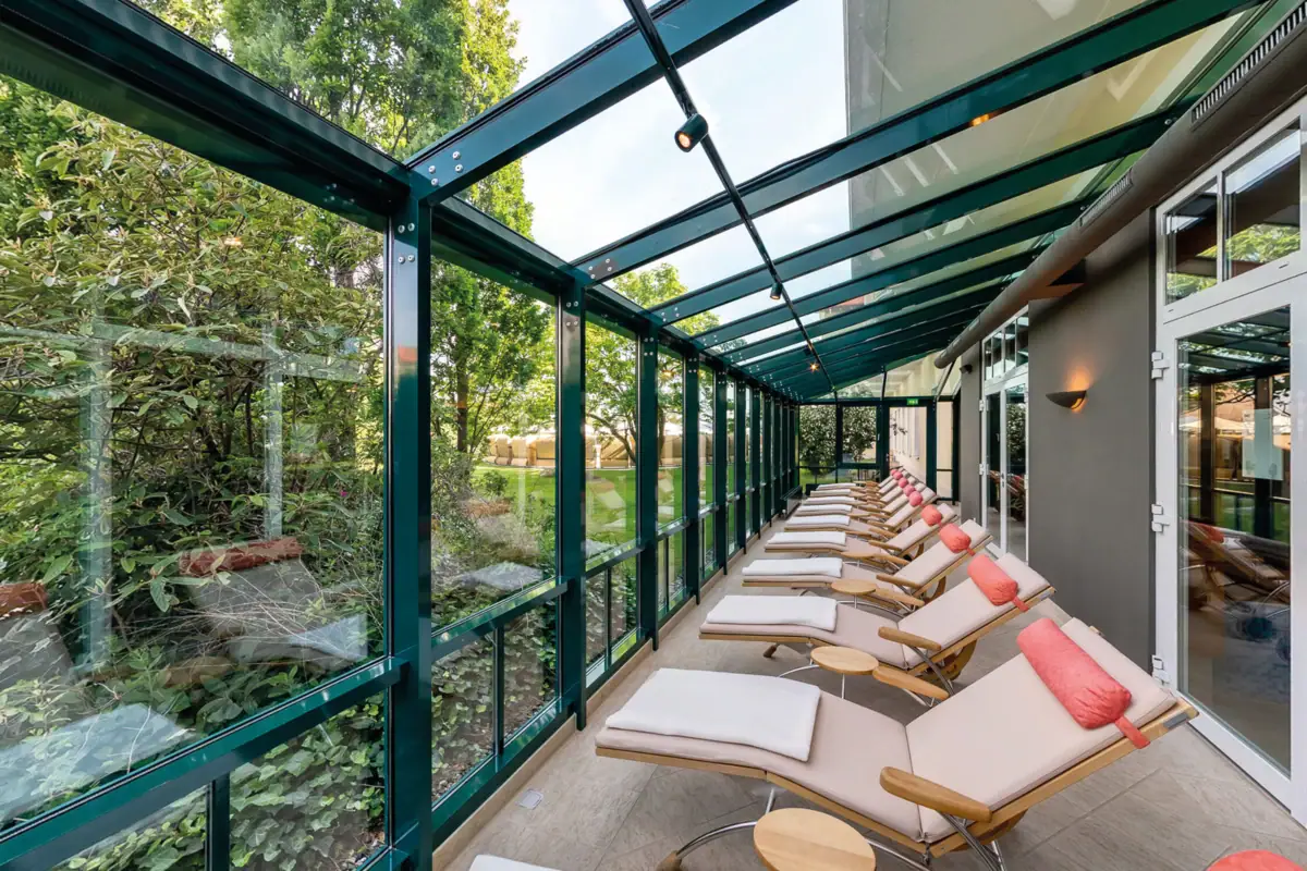 Eine Reihe von Liegestühlen in einem Raum mit Glaswänden.