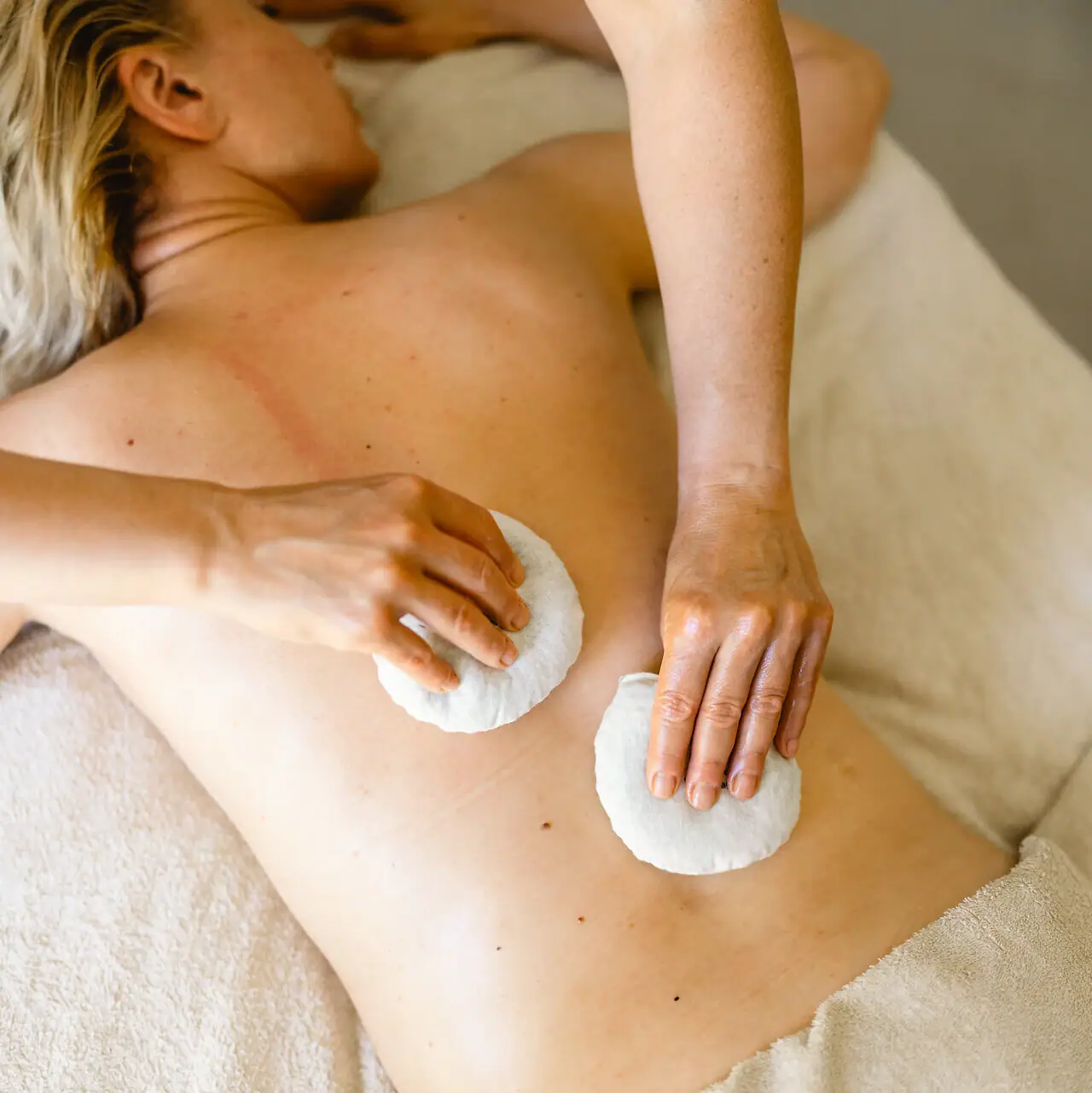 Eine Person liegt auf einem Massagetisch.