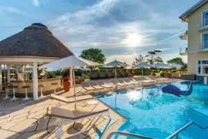 Wellness Außenpool Ein Pool mit Liegestühlen und Sonnenschirmen.