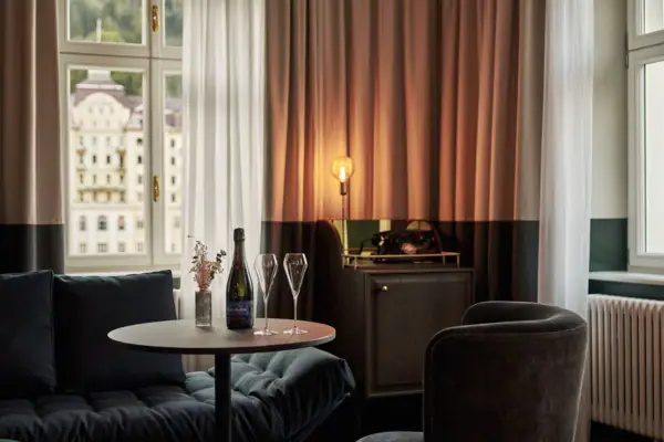 Zimmer Ein Tisch mit Weingläsern und einer Lampe vor einem Fenster.