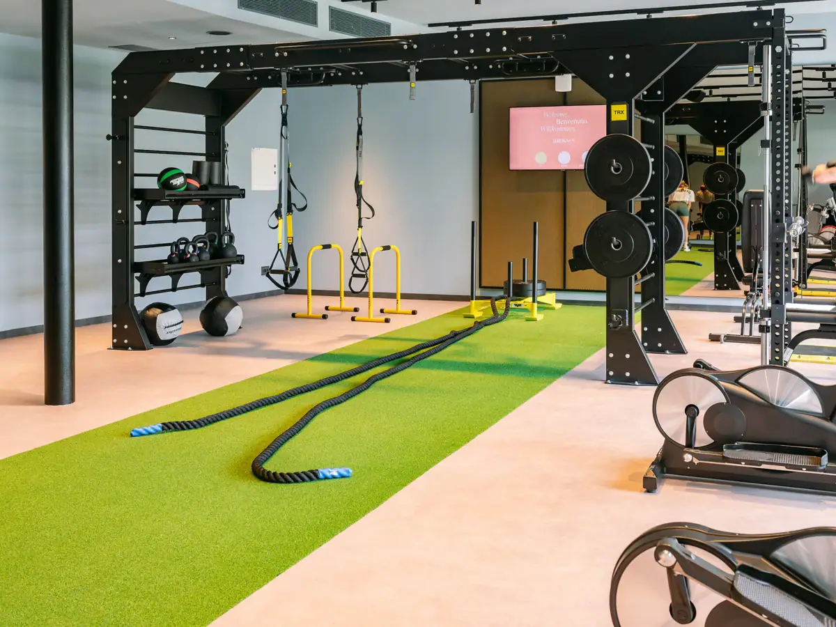 Fitnessstudio mit grünem Teppich und schwarzem Metallrahmen