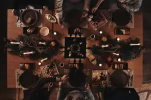 Raclette Eine Gruppe von Menschen sitzt um einen Tisch mit Essen.