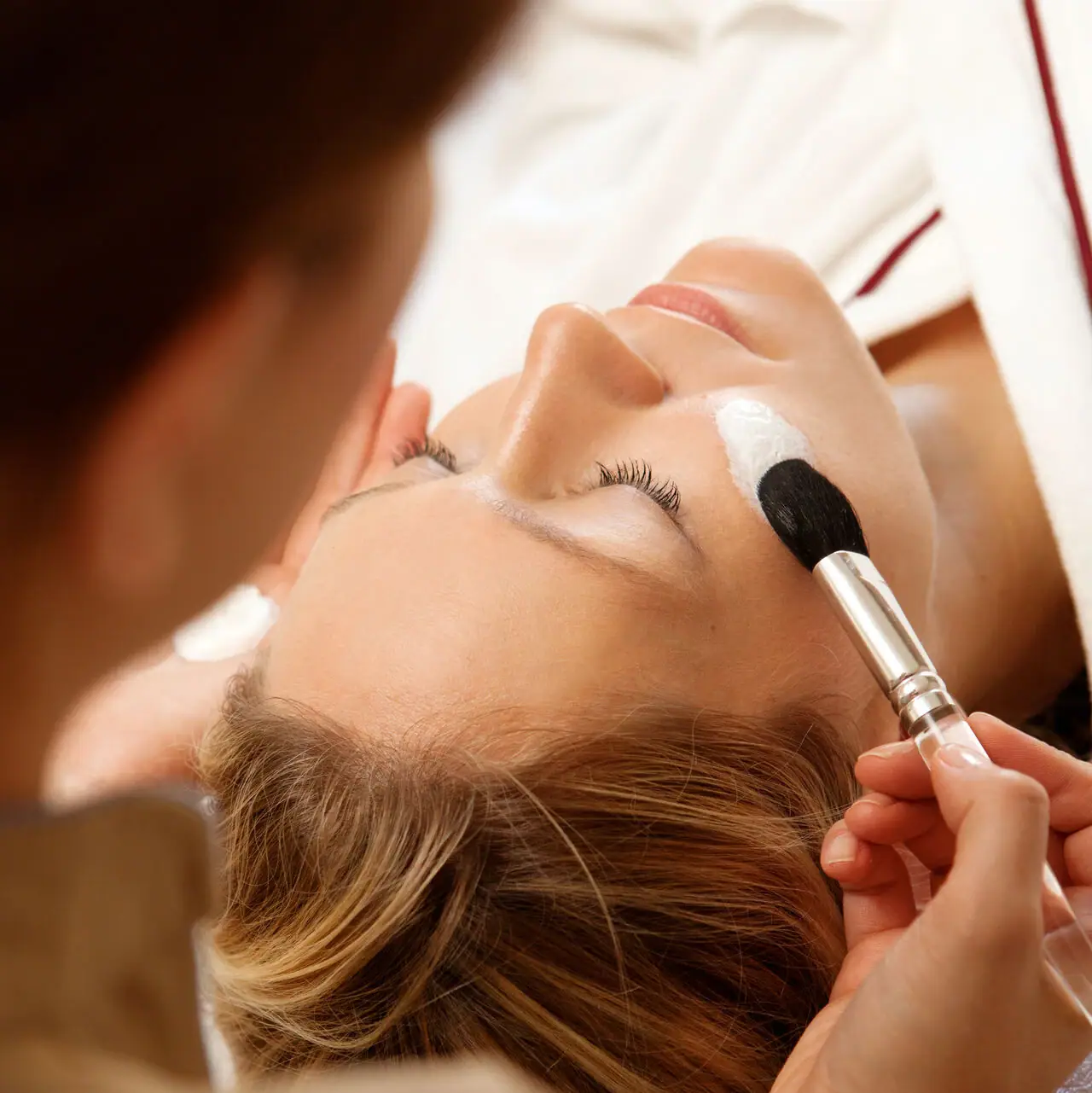 A-ROSA Sylt Spa Anwendungen Eine Frau bekommt eine Gesichtsmaske aufgetragen.