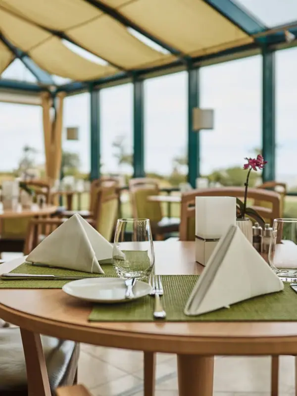 Ein gedeckter Restauranttisch mit Tischgeschirr und Tischdecke.