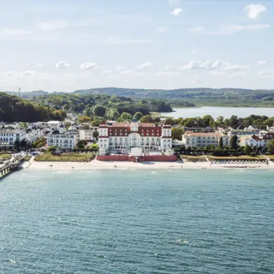 Großes weißes Gebäude neben einem Gewässer.