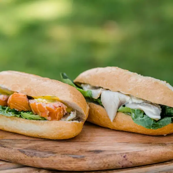 Zwei Sandwiches auf einem Holzbrett.