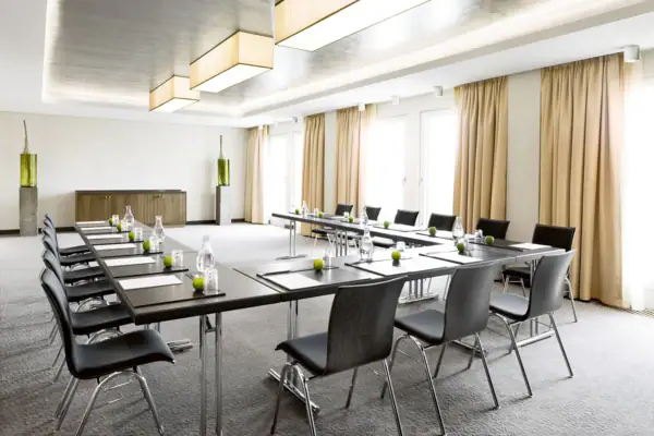 Veranstaltungsraum In einem Veranstaltungsraum stehen einige Tische und Stühle in U-Form.