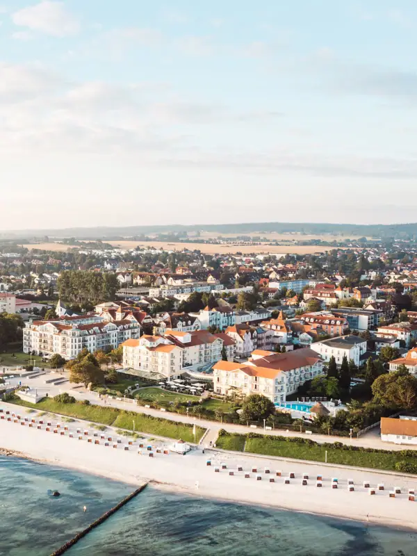 Stadt neben einem Gewässer mit Gebäuden und wolkigem Himmel.