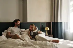 Zimmer Ein Mann und eine Frau liegen auf einem Bett in einem gemütlichen Zimmer.