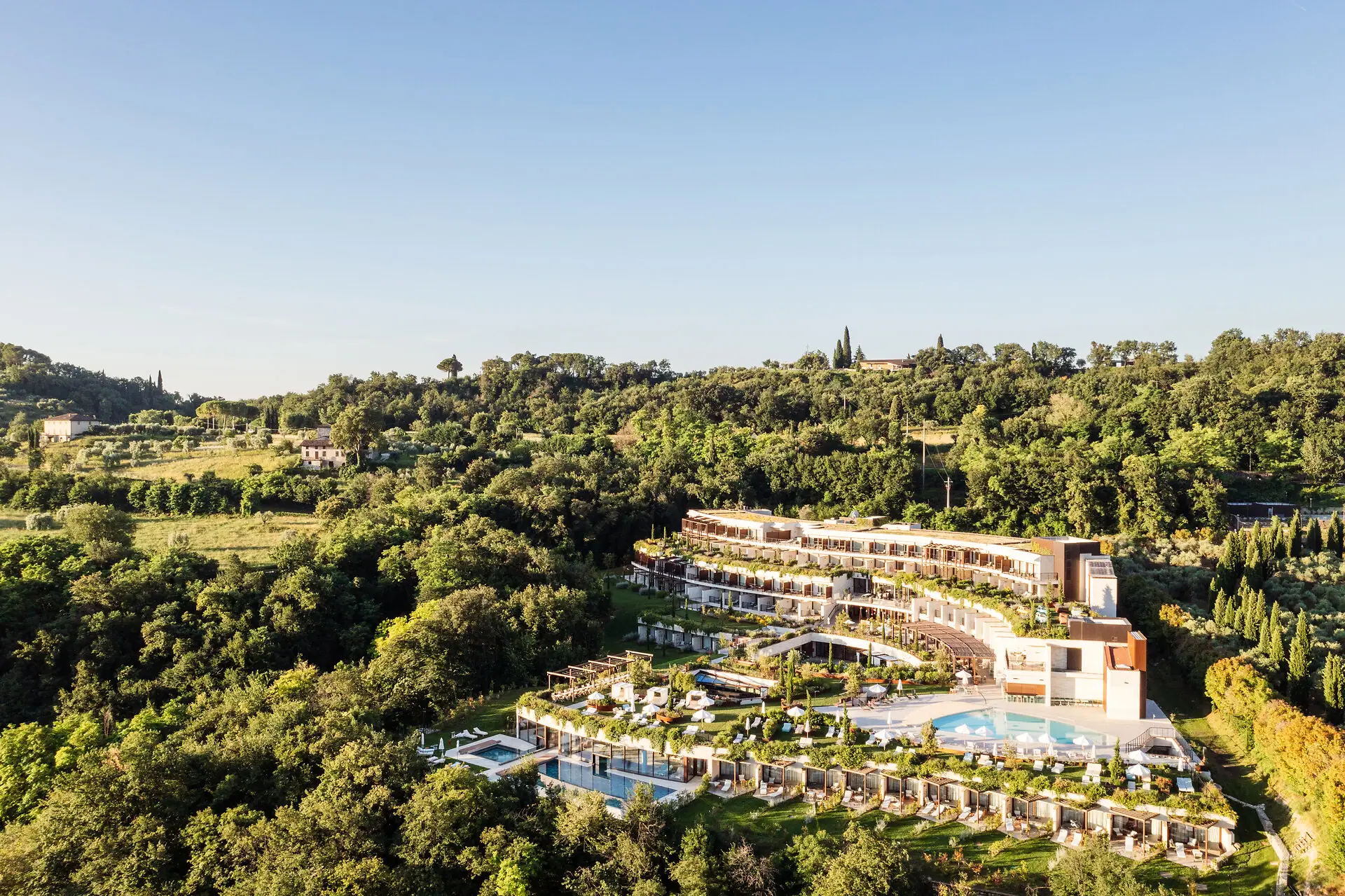 A-ROSA Hotel am Gardasee Ein Gebäude mit einem Pool, umgeben von Bäumen.