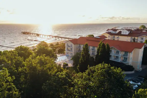 Ein Gebäude neben dem Wasser im Freien mit Bäumen und Himmel im Hintergrund.