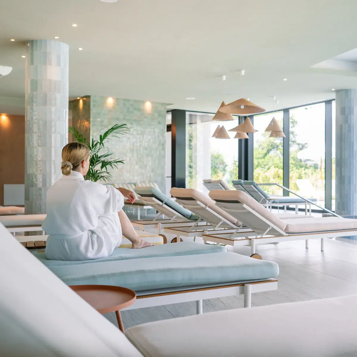 Eine Frau sitzt in einem Raum mit Lounge-Stühlen.