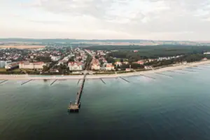 A-ROSA Ostseehotel Kühlungsborn Wasserfläche mit einem Steg und Gebäuden im Hintergrund.