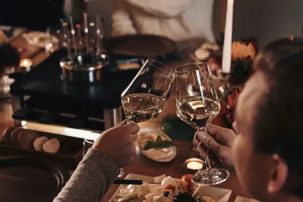 Ein Paar stößt mit Weingläsern an.