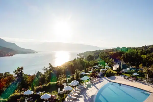 SPA-ROSA Poollandschaft mit Seeblick Gartenpool des A-ROSA Gardasee mit Liegen und Panoramablick auf den Gardasee