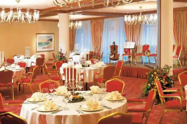 Hochzeitssaal Ein Raum mit Tischen und Stühlen, dekoriert mit Tischdecken und Tischdekorationen.