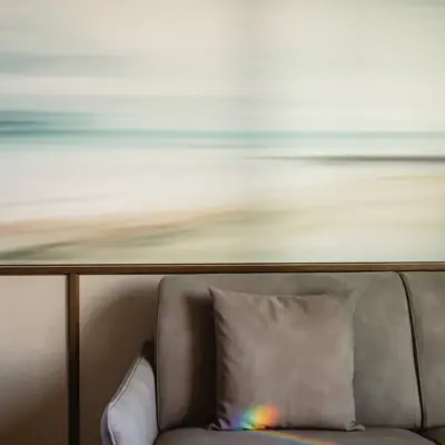 Highlights Couch mit Kissen vor verschwommenem Strandbild im Hintergrund