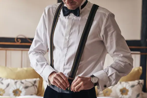 Ein Mann mit Hosenträgern und Fliege.