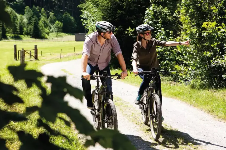 Ein Mann und eine Frau fahren auf einem Weg Fahrrad.