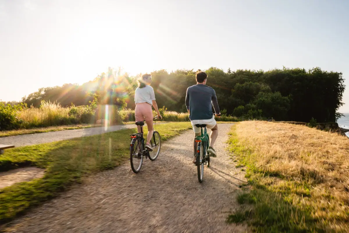 Ein Mann und eine Frau fahren auf einem Weg Fahrrad.