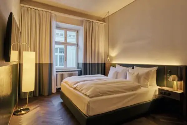 Ein Bett in einem Zimmer mit eleganter Bettwäsche und Kissen.