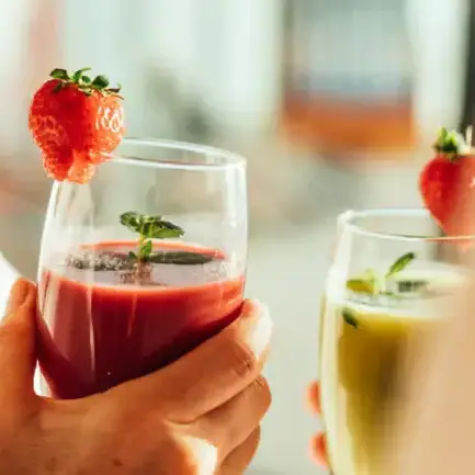 Smoothie Eine Person hält Gläser mit Früchten.