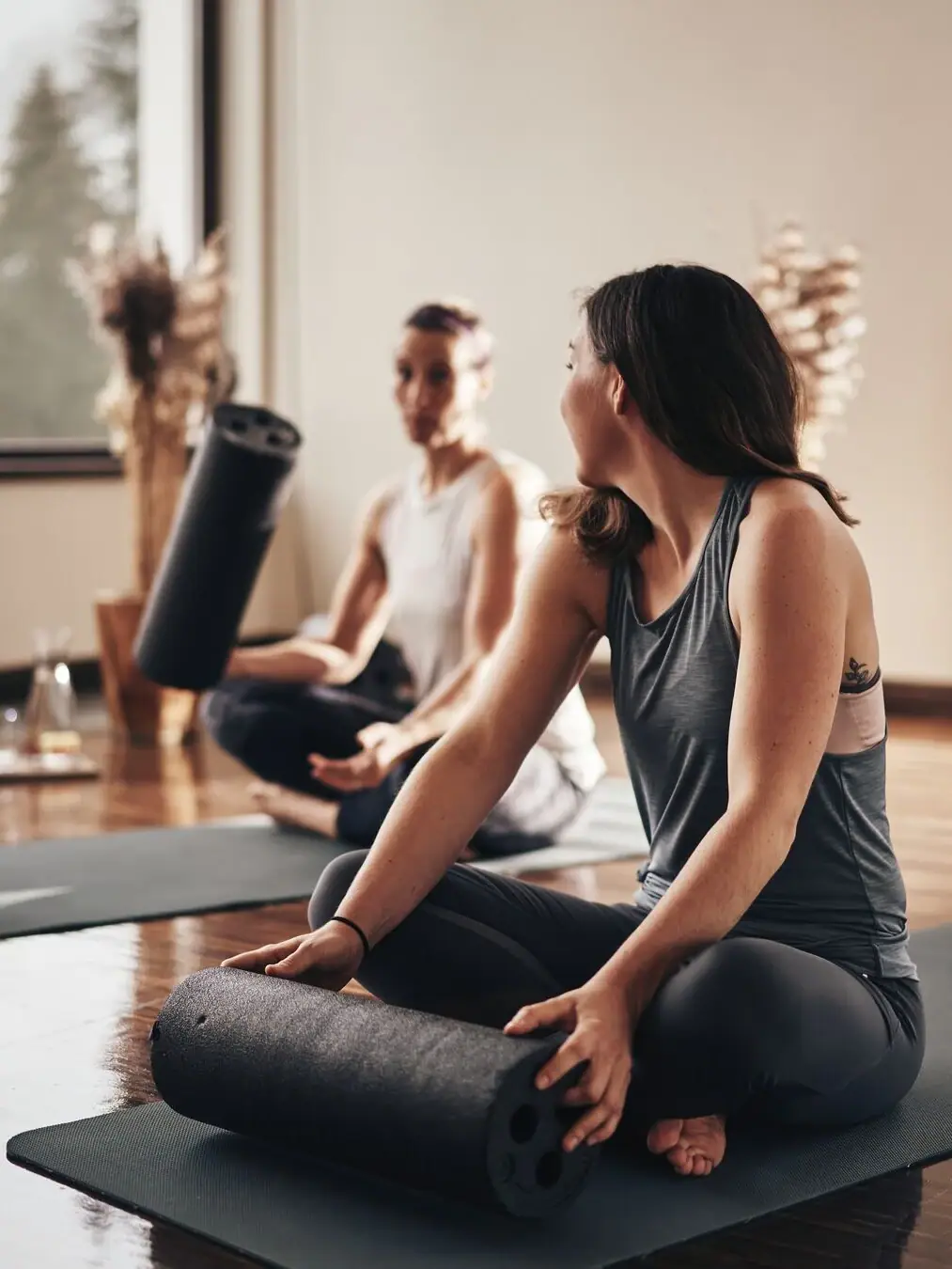 Eine Gruppe von Frauen sitzt auf Yogamatten.