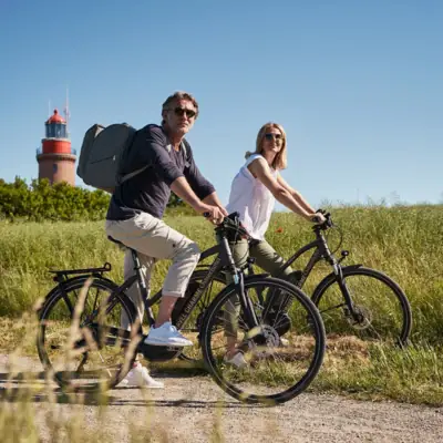 Ein Mann und eine Frau fahren mit Fahrrädern auf einem Weg.