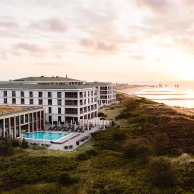 Ein Gebäude mit einem Pool am Wasser unter freiem Himmel.